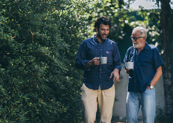 An elderly man talking to a young man