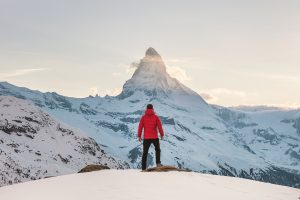 Young man in snow looking at mountain